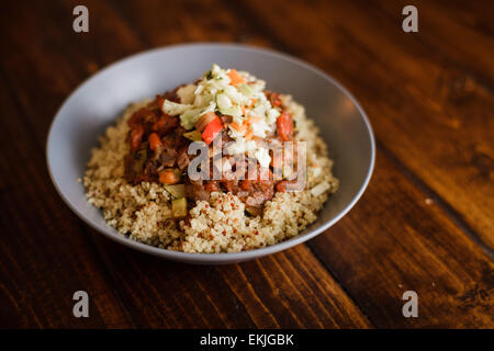 Dîner végétalien composé de Quinoa, sauce tomate avec des légumes et de la salade de chou sur le dessus Banque D'Images