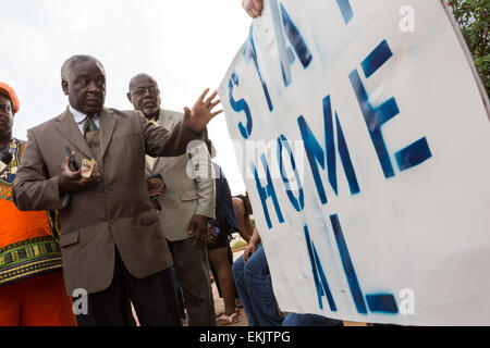 Un leader local soutient avec un homme tenant un signe s'opposant à la visite prévue du Révérend Al Sharpton à l'extérieur de l'Hôtel de Ville de North Charleston pendant un rassemblement après la mort de Walter Scott le 10 avril 2015 à Charleston, Caroline du Sud. Scott a été tourné plusieurs fois par la police après l'exécution d'un arrêt de la circulation. Banque D'Images