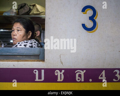 Bangkok, Bangkok, Thaïlande. Apr 11, 2015. Une femme regarde par la fenêtre d'un wagon de train 3e classe à la gare de Hua Lamphong à Bangkok. Plus de 130 000 passagers acheminées via la gare principale de Bangkok vendredi en avant de Songkran, le nouvel an traditionnel. Songkran sera célébrée du 13 au 15 avril mais les gens commencer à diffuser en continu hors de Bangkok le 10 avril pour retourner dans leurs provinces d'origine. Crédit : Jack Kurtz/ZUMA/Alamy Fil Live News Banque D'Images