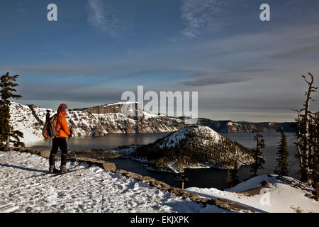 OREGON - un cross-country skier au branchement avec vue sur l'île de l'assistant et Llao Rock à partir de la neige au lac Crater Rim Drive. Banque D'Images