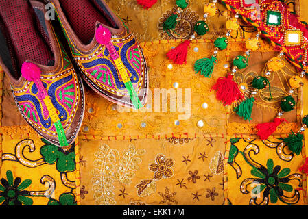 Chaussures ethniques colorés et tsigane sur la courroie du Rajasthan jaune coussin sur marché aux puces de l'Inde Banque D'Images