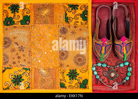 Chaussures ethniques colorés, collier et jaune housse de coussin du Rajasthan en Inde sur le marché aux puces Banque D'Images