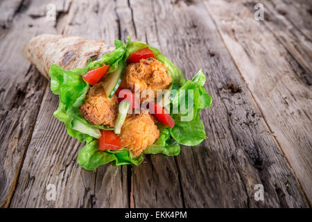 Languettes de poulet avec de la laitue Tortilla sur le bois. Banque D'Images