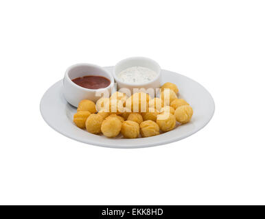 Les billes de pommes de terre avec la sauce sur un plat sur fond blanc Banque D'Images