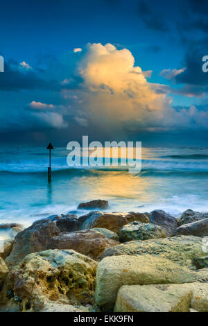 Nuages de pluie se bloquer sur l'horizon de la réflexion dans le casting toujours les eaux au large de la côte du Dorset Banque D'Images