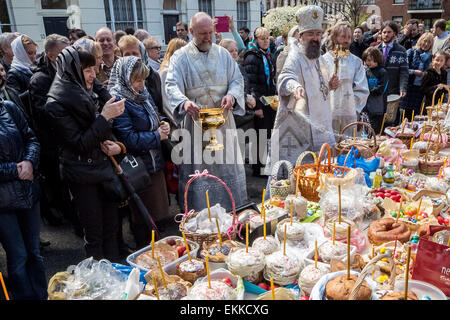 La base britannique russes et d'autres chrétiens orthodoxes de l'est de recueillir à l'extérieur de l'église Russe, Diocèse de Sourozh, à Londres, avec leurs paniers de Pâques (Easter) contenant les œufs décorés et des gâteaux pour recevoir des bénédictions de Pâques par Mgr Elisey de Sourozh sur grand samedi. Banque D'Images