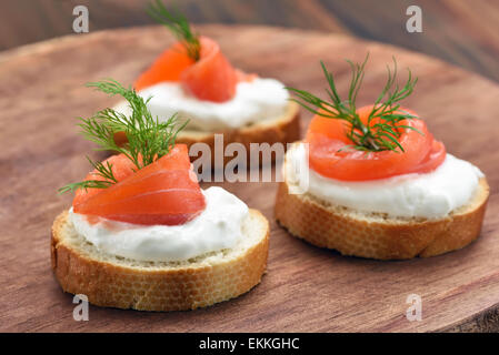 Le pain avec le saumon sur planche à découper en bois, vue en gros Banque D'Images