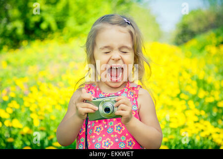 Petite fille à prendre des photos sur un pré Banque D'Images