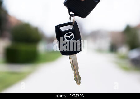 Sombor, Serbie - Avril 6 E,2015 : séance photo de différentes clés de voiture;main tenant une clé de voiture avec Mazda et route dans la rue Banque D'Images