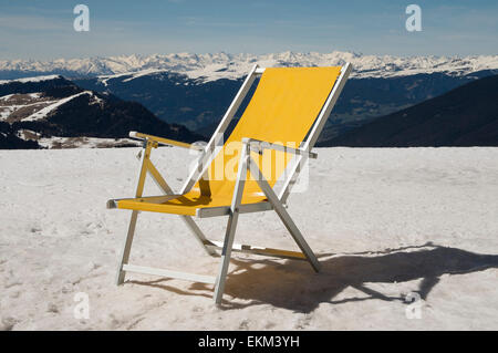 Transat jaune sur la neige montagne avec des montagnes enneigées au-delà Banque D'Images