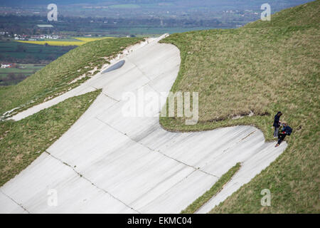 Wiltshire, Royaume-Uni. 12 avril, 2015. Météo France : Forte haut vent soufflant sur le cheval blanc de craie au-dessus de la ville de Westbury. Les vents forts n'a pas arrêté de nombreux membres de la population de visiter et d'utiliser le temps de marche, promenade des chiens, voler des cerfs-volants et profiter de la vue imprenable sur toute la vallée du Wiltshire. Le site est protégé par l'English Heritage qui maintiennent l'ancien âge de fer de la saison de pâturage fort en permettant aux troupeaux de moutons pour maintenir les herbes et broussailles chalk favorable plantes. Credit : Wayne Farrell/Alamy Live News Banque D'Images