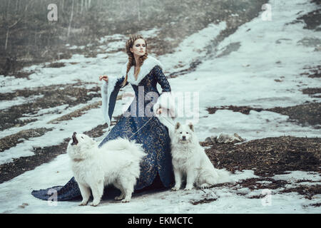 La femme sur l'hiver à pied avec un chien Banque D'Images