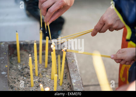 Londres, Royaume-Uni. 12 avril 2015. Bougies d'éclairage fidèles alors qu'ils célèbrent le Nouvel An Thaï (Songkran) à Buddhapadipa Temple à Wimbledon, le seul temple thaïlandais au Royaume-Uni volontairement construit dans le style architectural thaï. Les invités ont pris part à des cérémonies religieuses, apprécié la musique classique thaï et la danse des spectacles, un concours de beauté Miss Songkran ainsi que des stands vendant de la nourriture thaïe, l'épicerie et de souvenirs. Crédit : Stephen Chung/Alamy Live News Banque D'Images