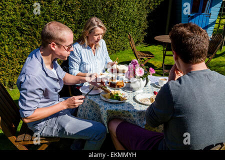 Une famille Profitez d'un thé anglais traditionnel l'après-midi, Glynde, Sussex, UK Banque D'Images