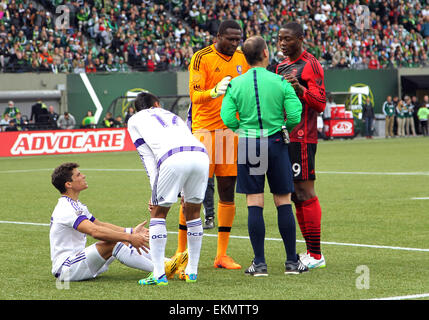 Portland, Oregon, USA. 12 avril, 2015. Orlando City FC gardien Donovan Ricketts (1) et Portland Timbers avant Fanendo Adi (9) à la fois plaider leur cause devant l'arbitre Kevin Stott pour faute présumée contre Orlando City FC defender Rafael Ramos (27) (assis) dans la seconde moitié du match entre MLS Orlando City FC et les Timbers de Portland à Providence Park, Portland, OU Crédit : Cal Sport Media/Alamy Live News Banque D'Images