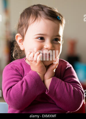 Cute baby girl en violet à côté de rire Banque D'Images