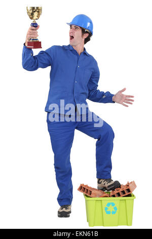 Constructeur recyclage holding trophy Banque D'Images