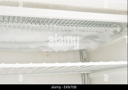 Le temps de décongeler une glace laden congélateur inefficace avec des couches de glace de l'eau gelée sur les éléments et la durée de l'intérieur Banque D'Images