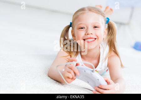 Fille jouant sur une console de jeu Banque D'Images