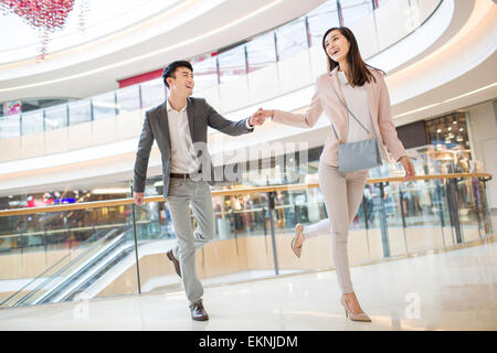 Jeune couple walking in shopping mall Banque D'Images