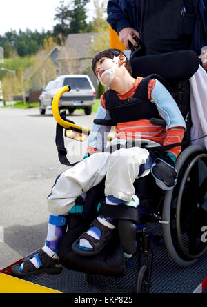 Mobilité boy on school bus élévateur de fauteuil roulant Banque D'Images