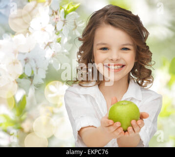 Happy girl holding apple sur fond de jardin Banque D'Images