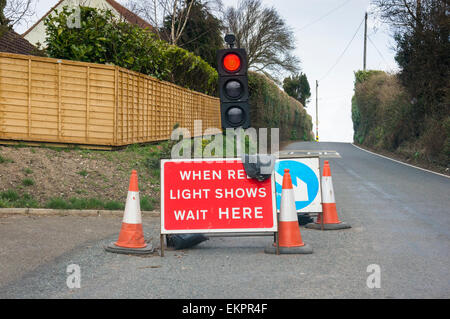 Feux de circulation dans un petit village sur un pays rural road, England, UK Banque D'Images