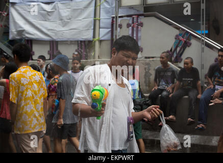 Bangkok, Thaïlande. 13 avril, 2015. Un jeune homme prend part à l'eau lutte sur Silom Road, Bangkok le 13 avril 2015, dans le cadre de la fête de Songkran. Aujourd'hui est le premier des trois jours de festivités où les gens sont à la rue et jeter l'eau dans la célébration de la nouvelle année Crédit : Alison Teale/Alamy Live News Banque D'Images