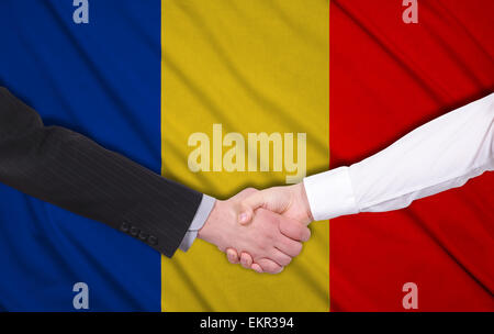 Deux businessmen shaking hands sur fond du drapeau de la Roumanie Banque D'Images