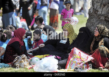 Le Caire, Égypte. 13 avr, 2015. Les enfants égyptiens avec leurs familles s'asseoir à un jardin au Caire le 13 avril 2015. Les égyptiens célèbrent la Sham El Nessim, ou le Festival de brise de printemps, qui marque le début du printemps Crédit : Amr Sayed/APA/Images/fil ZUMA Alamy Live News Banque D'Images