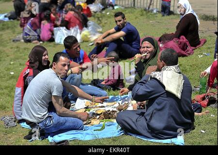 Le Caire, Égypte. 13 avr, 2015. Les enfants égyptiens avec leurs familles s'asseoir à un jardin au Caire le 13 avril 2015. Les égyptiens célèbrent la Sham El Nessim, ou le Festival de brise de printemps, qui marque le début du printemps Crédit : Amr Sayed/APA/Images/fil ZUMA Alamy Live News Banque D'Images