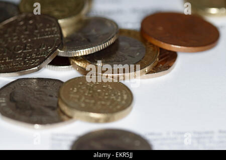 Pile de pièces de monnaie britanniques de diverses confessions sur feuille de papier Banque D'Images