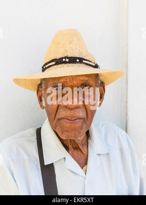 Head and shoulders portrait of a Senior citizen afro-cubaine en chapeau de paille face à l'avant. Banque D'Images