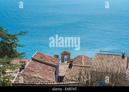 Vue vers le bas pour le bleu azur de la mer Méditerranée sur le toits en terre cuite d'Eze Village sur une journée ensoleillée Banque D'Images