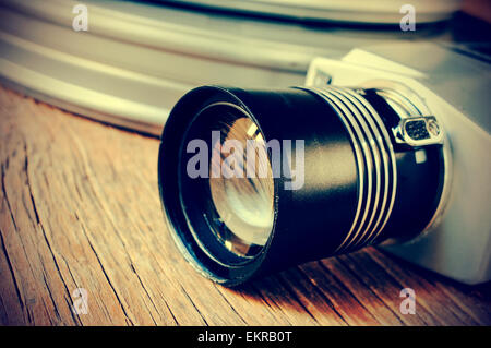 Libre d'un appareil photo de film retro et certains metal film canisters bobine de film sur une surface en bois rustique, filtrée et légère vignette Banque D'Images