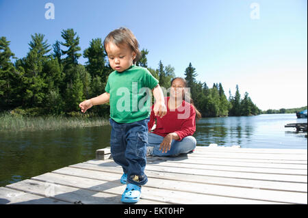 Mère autochtone sur un quai avec son fils à Shoal Lake, Ontario, Canada. Banque D'Images