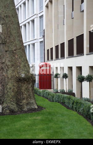 Une boîte de téléphone rouge traditionnel de Londres sur Fetter Lane dans la ville de Londres - encadré par des jardins nouvellement installé Banque D'Images