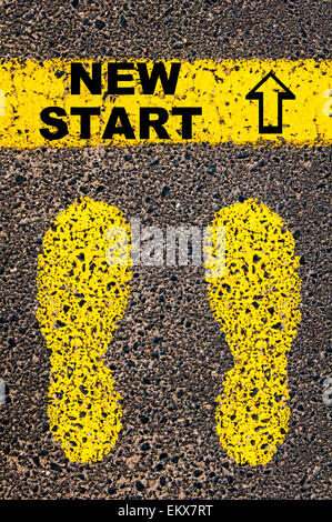 Nouveau message de démarrage. Image conceptuelle avec traces de peinture jaune sur la route en face de ligne horizontale sur fond noir en asphalte. Banque D'Images