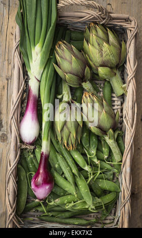 Dans un panier de légumes frais (artichauts, petits pois et oignons rouges de Tropea) Banque D'Images