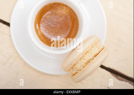 Macarons colorés avec une machine à expresso sur table en bois blanc Banque D'Images