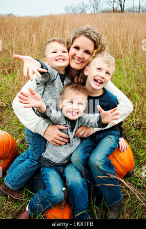 Mère tenant trois garçons dans ses bras Banque D'Images
