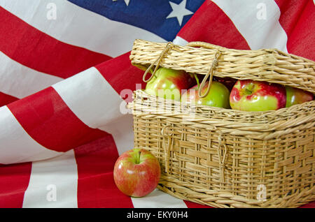 Pommes dans un panier pique-nique en osier sur un drapeau américain. Banque D'Images