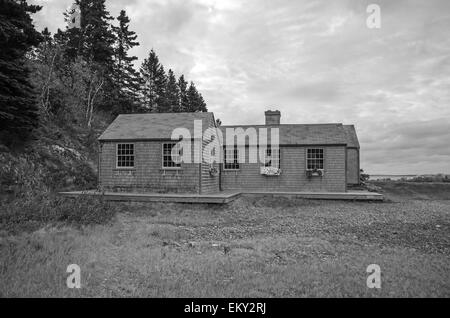 Un cottage de bardeaux donne sur une plage de galets à marée basse sur Mount Desert Island, dans le Maine. Banque D'Images