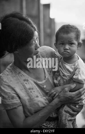 Une femme tenant un jeune enfant ; la Chine Yunnan Ruili Banque D'Images