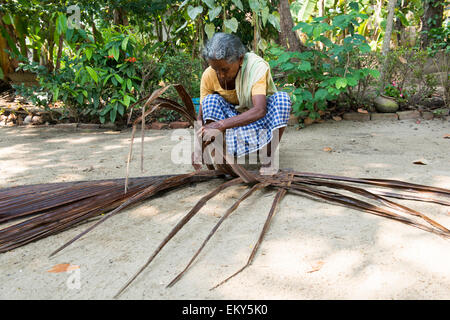 Une vieille femme indienne tisse un mat dans le cadre d'une authentique expérience de village pour les touristes à Kumarakom, Kerala, Inde Banque D'Images