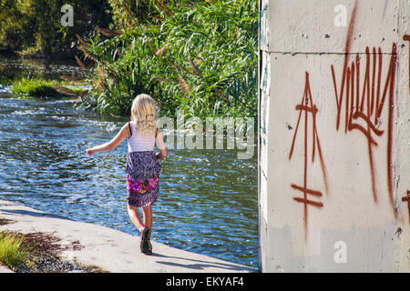 Jeune fille qui marche le long de rives de la Los Angeles River, Glendale, Narrows, Los Angeles, Californie, USA Banque D'Images