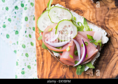 Les sandwiches ouverts avec du jambon, concombre, roquette et fromage sur une tranche de pain de seigle grillé au bois d'olive, vue d'en haut Banque D'Images