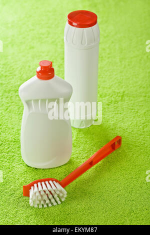 Brosse et bouteilles blanches sur fond vert Banque D'Images