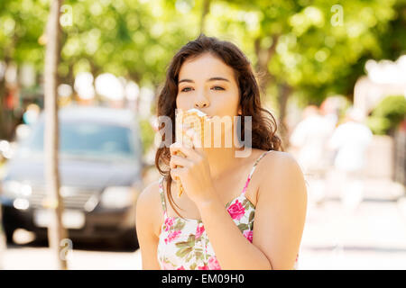 Portrait of young woman eating ice-cream Banque D'Images