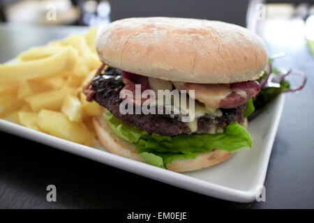 Bacon et fromage hamburger et des frites dans un gastropub Banque D'Images